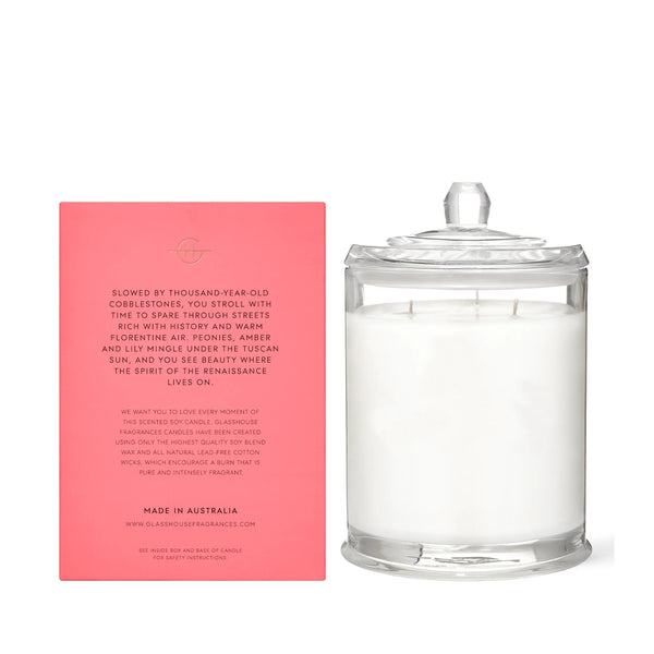 Glasshouse Fragrances' Forever Florence 13.4oz scented candle in an apothecary jar. The product's pink box sits next to the candle.