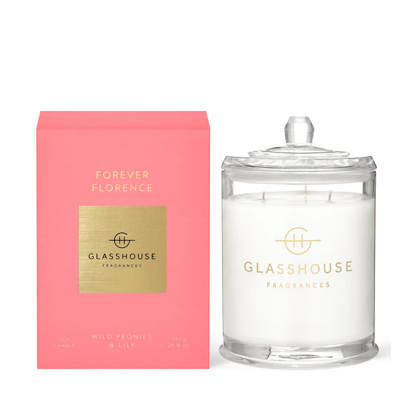 Glasshouse Fragrances' Forever Florence 13.4oz scented candle in an apothecary jar. The product's pink box sits next to the candle.