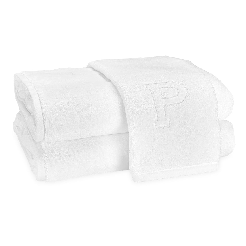 A stack of two bath towels and one hand towel laid on top with the block letter "P" initial.