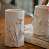 White glazed pottery vase from Cabell's Designs is decorated with a daffodil floral relief.