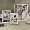 Collection of silver photo frames rests on a tabletop.