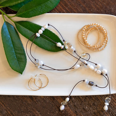 Tray with freshwater pearl bolero necklance, enewton gold bead bracelets and gold hoop earrings