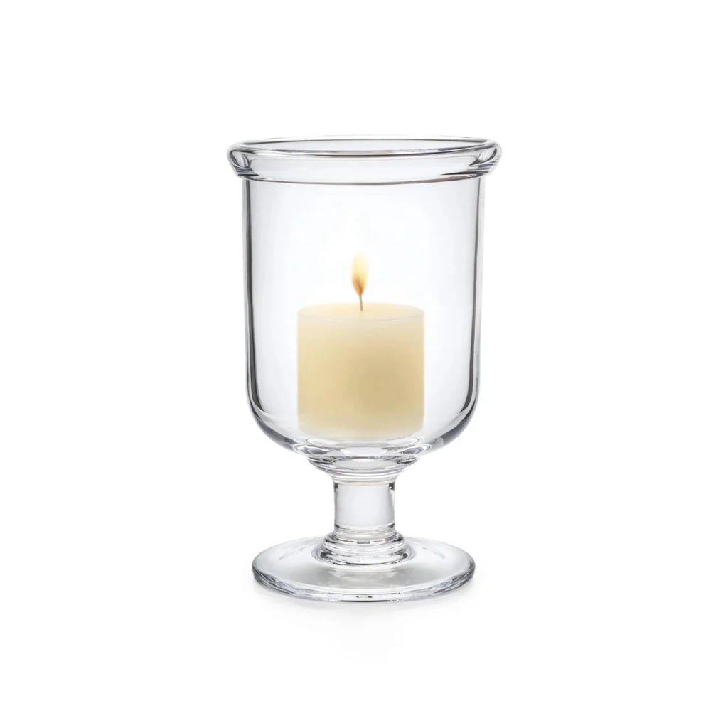 Glass Simon Pearce Essex Hurricane with lit candle on white background.