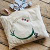 Hand painted fabric pouch with mahjong tiles on wooden table. 