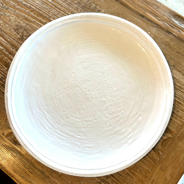 Cream double line melamine dinner plate on wooden surface.