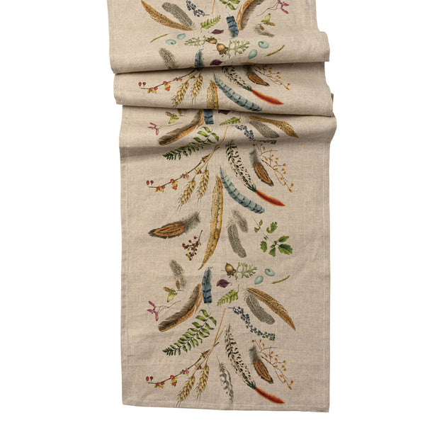 Natural linen table runner with renderings of feathers, leaves, eggs, acorns and other natural objects. 