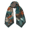 A knotted scarf designed by Sabina Savage. This scarf depicts a snow lion of Tibet wearing traditional armor. The scarf 's design is colored in rich teal and oranges.