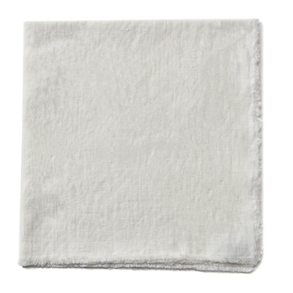 Natural colored linen and cotton fringed napkin on a white background.