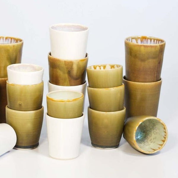 An stacked assortment of tall and short Allison Evans Oyster juice cups.