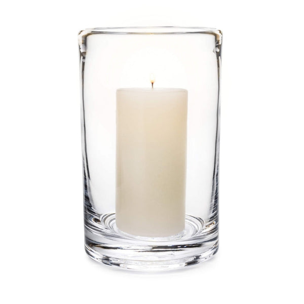 Clear glass cylindrical hurricane candle holder with cream candle on white background.