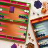 Two vibrant backgammon boards with pieces on a light surface.