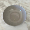 Stone, beaded serving bowl on marble counter.