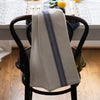 Blue and white  towel with blue stripes draped over a black chair in a kitchen setting.