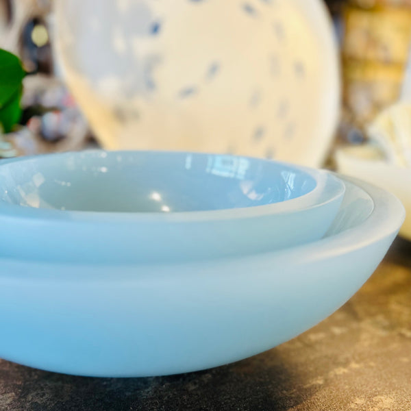 Light blue resin bowl on metal table with blurred background