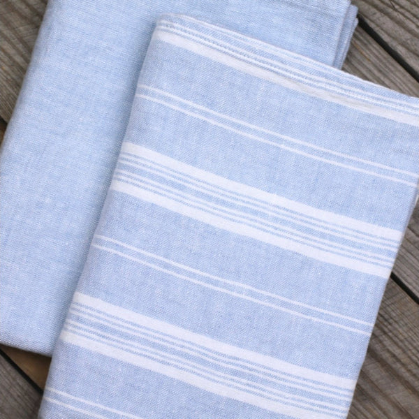 Blue and white striped linen hand towel on wooden table