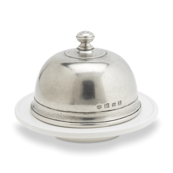 Pewter butter dome on a white cermic dish.