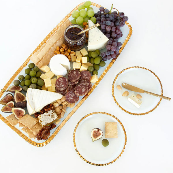 Gourmet charcuterie board with various foods on a white surface