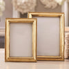 Two Chatelet gold photo frames stand vertically atop a table. One measures 4"x6" and one measures 5"x7."