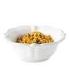 White scalloped berry and thread bowl filled with corn dip on a white background. 