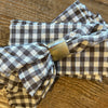 Brown and white checked napkins with horn napkin ring on wooden table. 