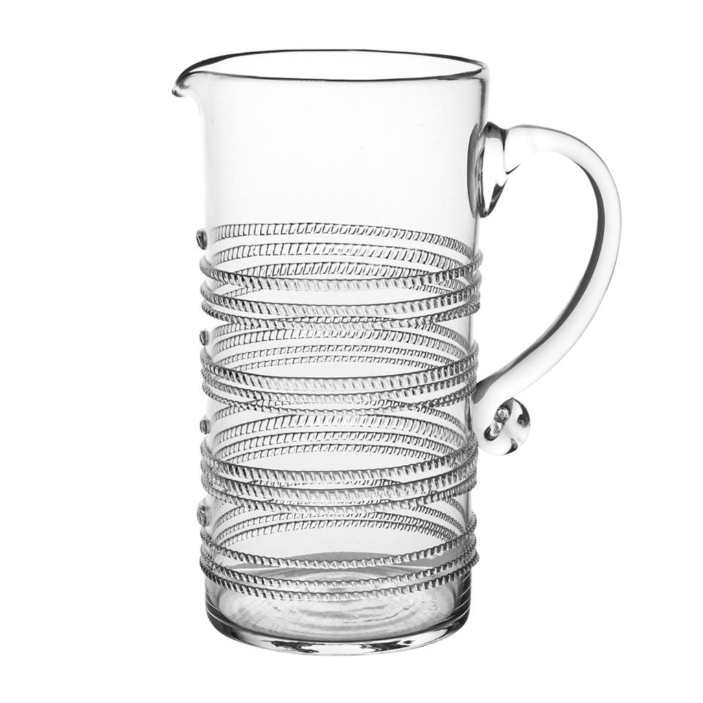 Clear bohemian glass pitcher with swirl pattern on a white background.