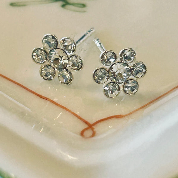 Sterling and crystal flower petal earrings on a porcelain dish. 