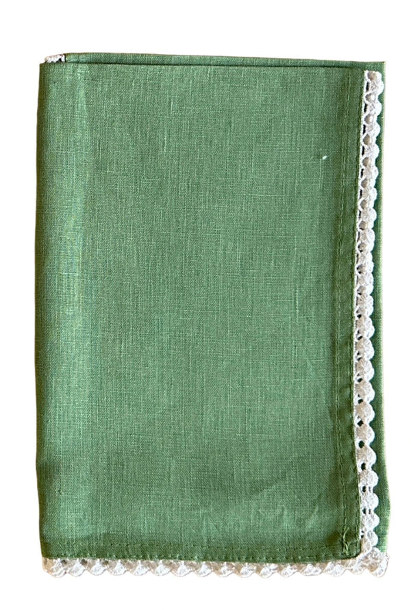 Green napkin with white crocheted edge on white background.