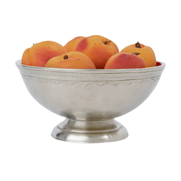 Small pewter bowl with peaches on white background.