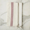 Two folded towels with a red stripe on a marble surface