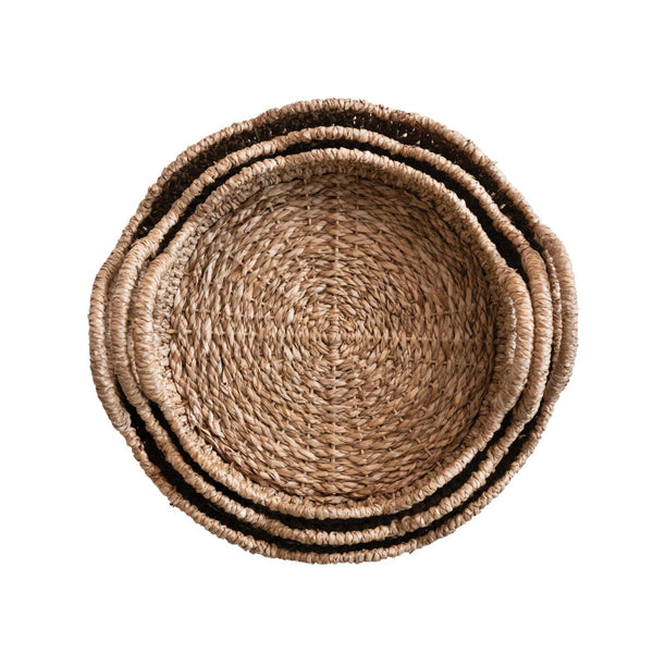 Nesting scalloped rattan trays on white background.
