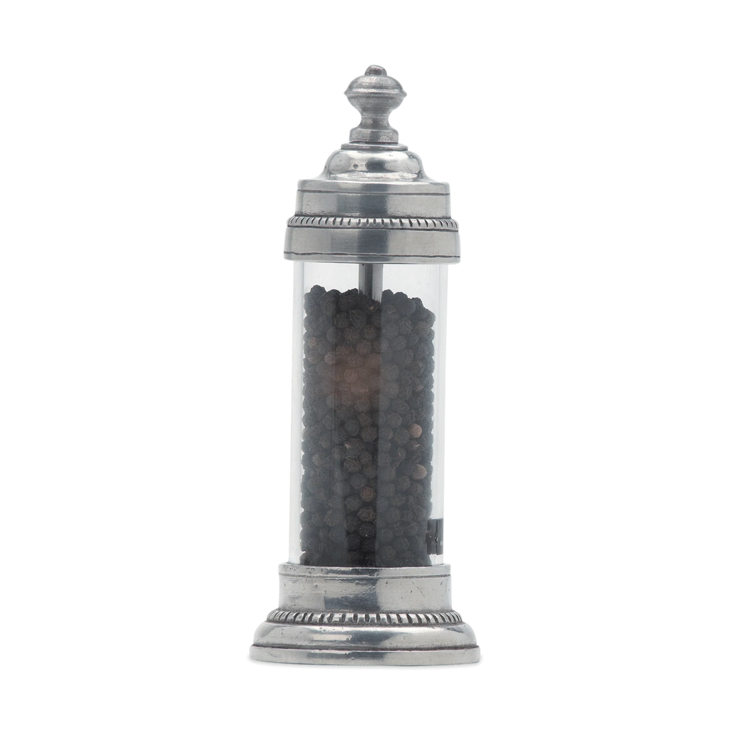 Pewter and glass pepper grinder on white background. 