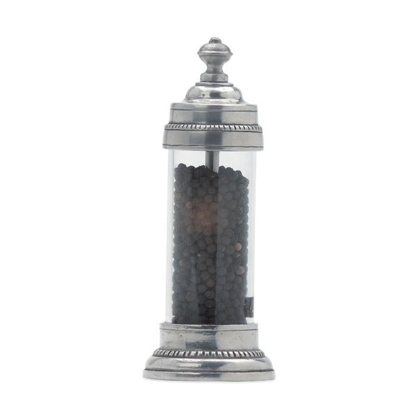Pewter and glass pepper grinder on white background. 