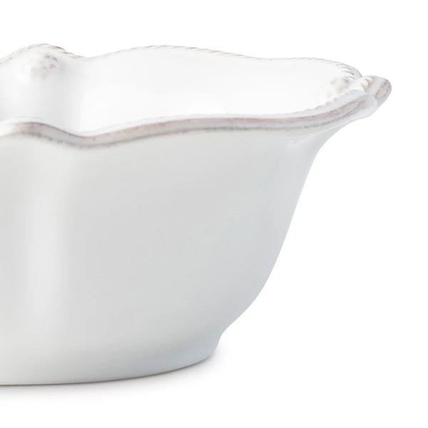 Detail of white scalloped berry and thread cereal bowl on white background. 