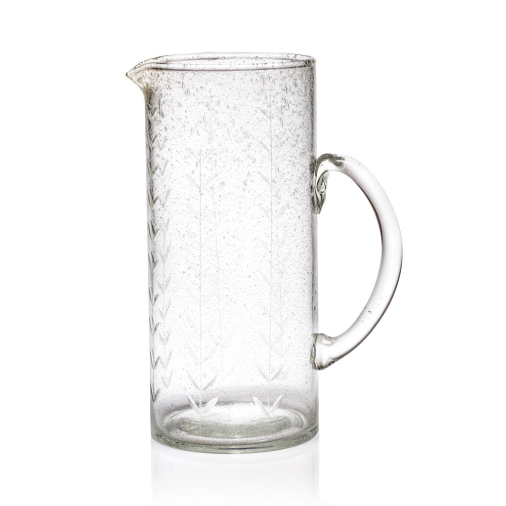 Hand etched glass pitcher on white background.