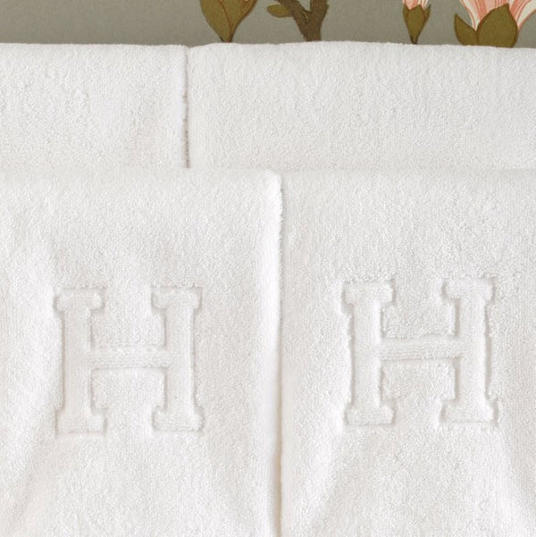 Close-up view of Matouk's Auberge initial towels with the block letter "H" initial.