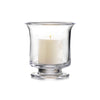 One medium Simon Pearce Revere Hurricane with the included pillar candle inside. These clear glass candleholders are 7 inches tall and 6.25 inches wide and have a sturdy flared base and flared top.