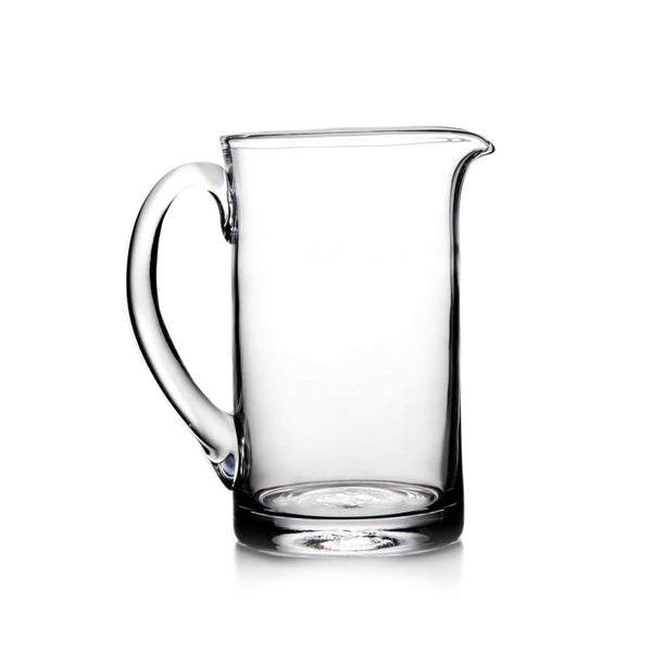 Round Simon Pearce Ascutney handmade clear glass pitcher with a pouring spout and simple handle. Medium measures 8.75 inches high and 8 inches around.