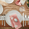 Tabletop display of Simon Pearce Burlington white dinner and side plates wtih cutlery, glassware, and pink napkins.