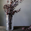 Large Simon Pearce Echo Lake vase is filled with branches of red eucalyptus.