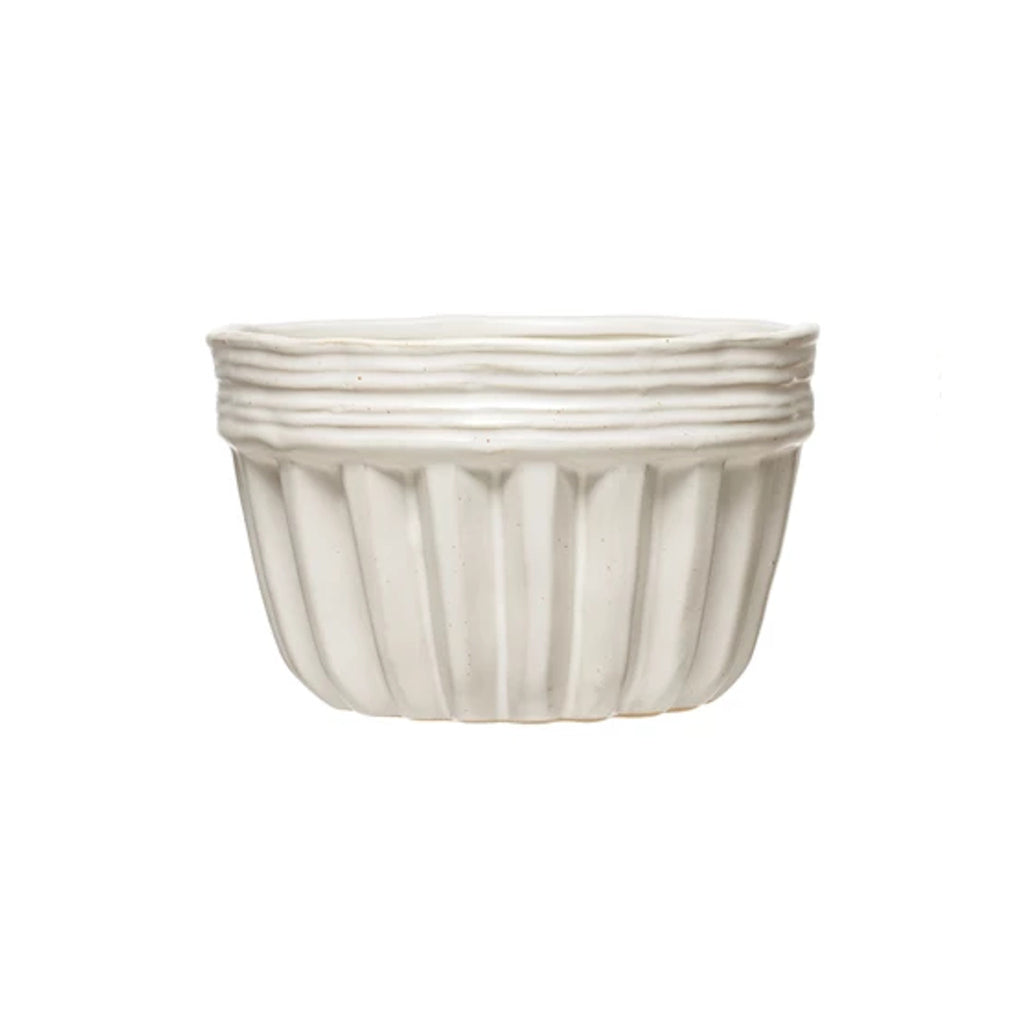 One white fluted stoneware bowl with a ridged rim.