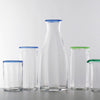 Four clear Lindean Mill optic tumblers with colored rims and one carafe with a blue rim.