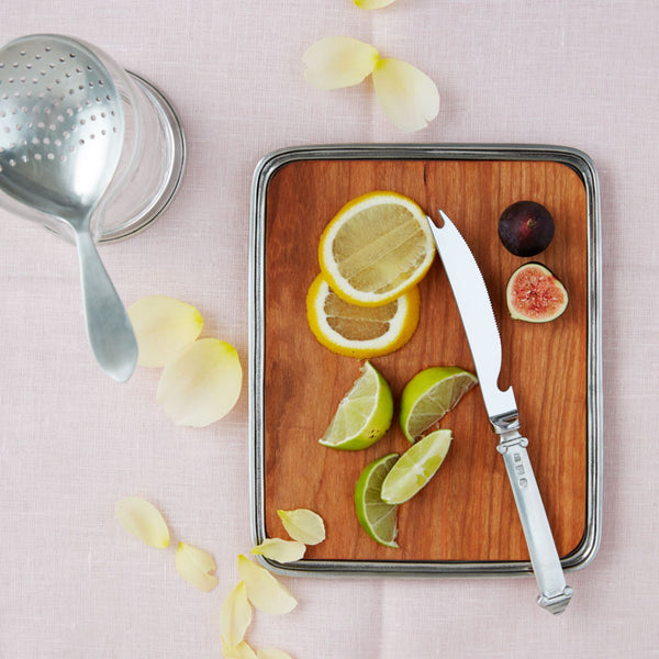 MATCH wooden tray edged in pewter. Shown as a cutting board with a knife and sliced citrus fruits.