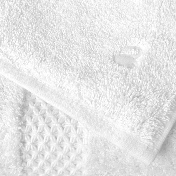 Close up of Yves Delorme Etoile white towel star design border and swan embroidered signature.